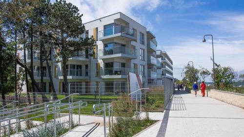 a building with people walking in front of it at Apartament Przy Plaży Arka , z widokiem na Morze :) in Mielno