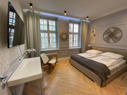 1 dormitorio con cama, lavabo y ventanas en Maya's Flats & Resorts 44 - Chlebnicka 17/18, en Gdansk