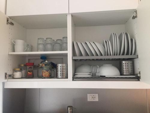 a kitchen cabinet with plates and dishes on shelves at Casa Angelo in Recco
