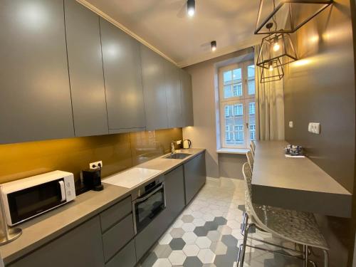 a kitchen with a sink and a microwave at Maya's Flats & Resorts 44 - 3 rooms apartment on Chlebnicka Street Gdańsk Old Town in Gdańsk