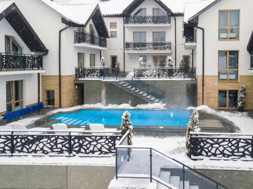 a house with a swimming pool in the snow at Chalet Fomich in Bukovel