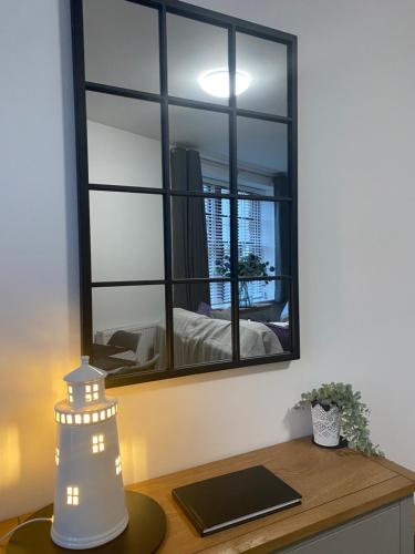 a mirror on a wall above a desk with a lamp at The Howff - Lovely 2-Bed Apartment in Anstruther in Anstruther