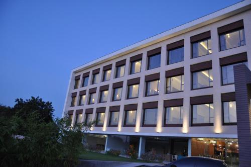 an office building with lights in the windows at Pride Biznotel Manjusar Vadodara Near Sokhda Lake in Vadodara