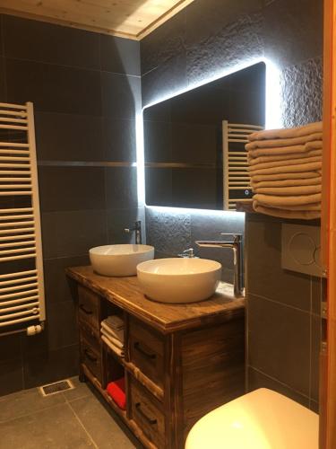 a bathroom with two sinks and a toilet at Apartment Anna in Courchevel