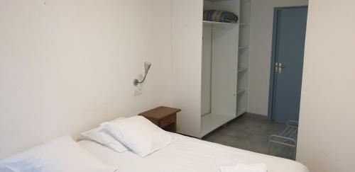 a bedroom with a white bed and a blue door at Presqu'île de Chooz in Chooz