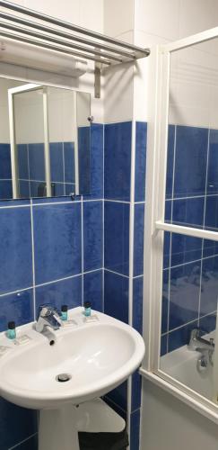 a blue tiled bathroom with a sink and a mirror at Presqu'île de Chooz in Chooz