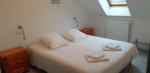 a bedroom with a white bed with towels on it at Presqu'île de Chooz in Chooz