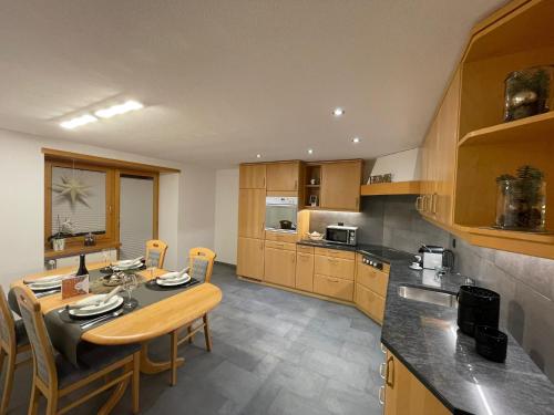 a kitchen with a table and some chairs in it at Apartment Bergfreude in Saas-Grund