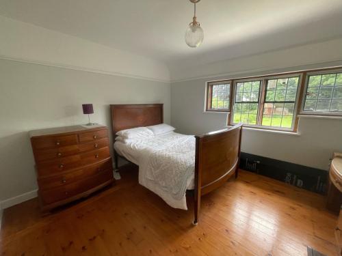 um quarto com uma cama, uma cómoda e janelas em Detached Private House em Margate