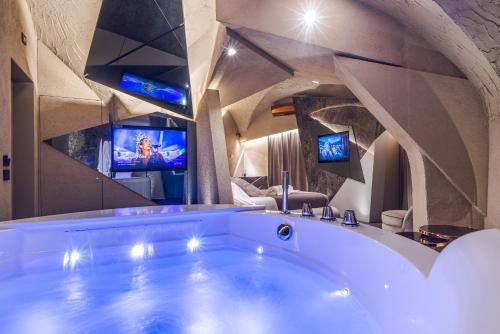 a large bath tub in a room with two televisions at Le Suites Del Duomo Luxury in Catania