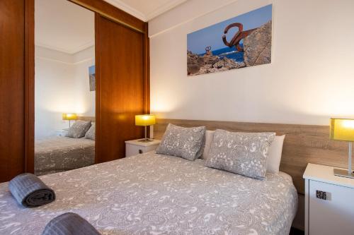 a bedroom with two beds and a mirror at San Sebastian Escape! in Loyola