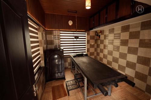 Zimmer mit Tisch und Herd in der Unterkunft Harmony Inn in Wayanad
