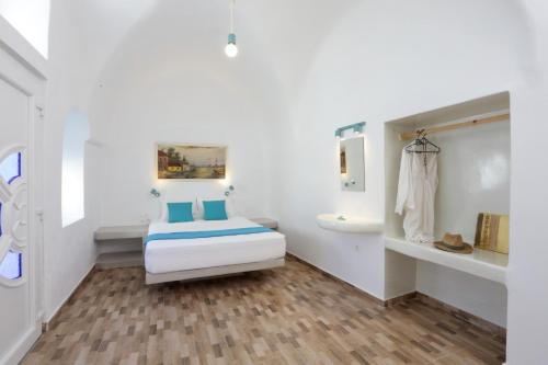 a white bathroom with a bed and a sink at Church and Cave - Santorini Private Residences in Mesaria