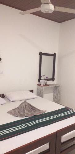 un letto in una stanza con uno specchio a parete di VILLA No34 HIKKADUWA a Hikkaduwa