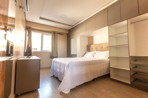 a bedroom with a bed and a large window at Apartamento a 200 metros da Praia do Cumbuco CE in Caucaia