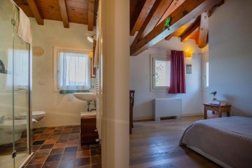 a bedroom with a bed and a tub and a sink at Ca' Dei Molini in Gruaro