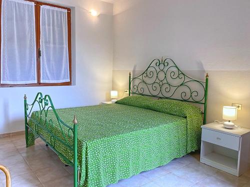 una camera con un letto verde e un copriletto verde di Villetta I Pini a Capoliveri