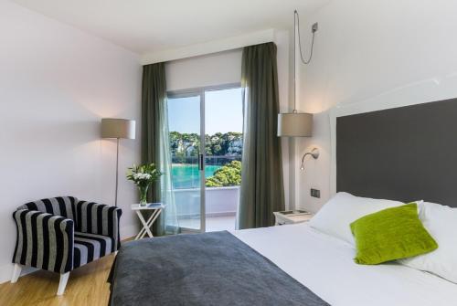 
a bedroom with a bed and a window at ARTIEM Audax - Adults Only in Cala Galdana
