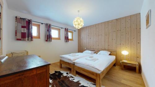 a bedroom with two beds and a chandelier at Modern chalet surrounded by nature in Vercorin in Vercorin