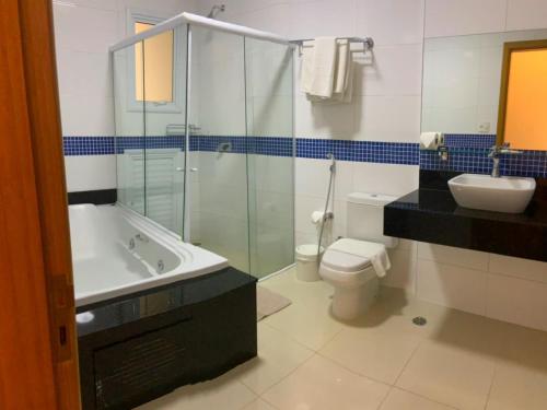 a bathroom with a glass shower and a toilet and sink at Hotel Amália in São Paulo