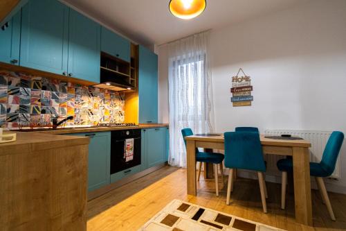 a kitchen with a wooden table and blue chairs at Lighthouse Central Apt with unique views of the Fortress, Free Parking, 5 min by car from the Old Town in Braşov
