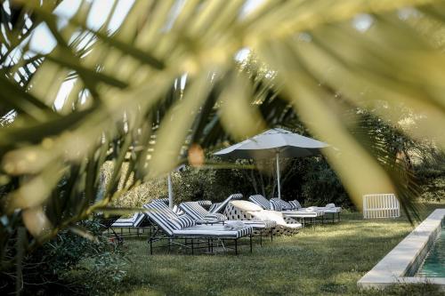 a group of chairs and an umbrella in the grass at Mas des Prêcheurs in Tarascon