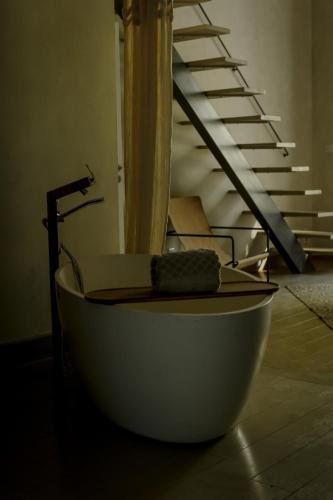 a bath tub sitting in a room with a staircase at Mas des Prêcheurs in Tarascon