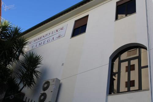 un bâtiment blanc avec un panneau sur son côté dans l'établissement Alojamento Local Tamega, à Amarante