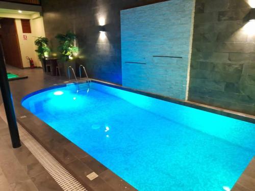 a large swimming pool with blue lighting at FH Hotel in Iquitos