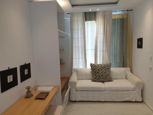a living room with a white couch and a table at Mare Monte Small Boutique Hotel in Chrysi Ammoudia