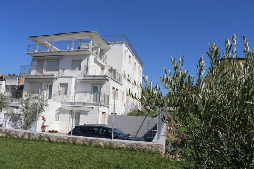 a white building with a car parked in front of it at Residence VILLA ADRIANA in Bardolino