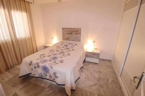 a bedroom with a bed with a blue and white blanket at Dinastia B403 by Tenerife Rental and Sales in Los Cristianos