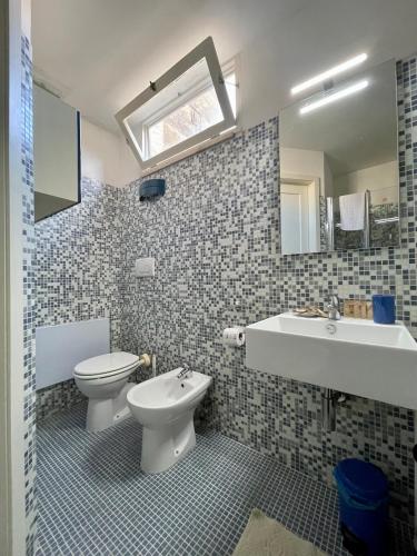 W łazience znajduje się toaleta, umywalka i lustro. w obiekcie 4 Balconi House-Appartamento salentino nel centro di Lecce w mieście Lecce