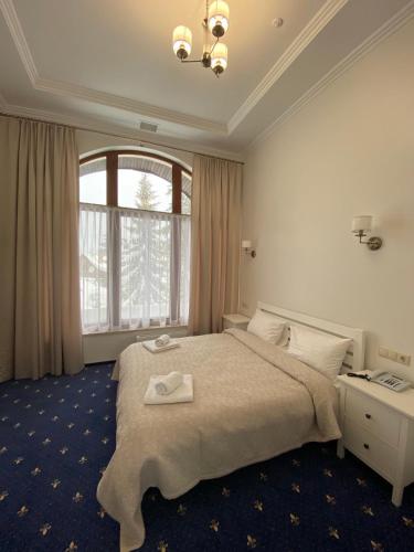 a bedroom with a large bed and a large window at Готель Вілла Драгобрат in Dragobrat