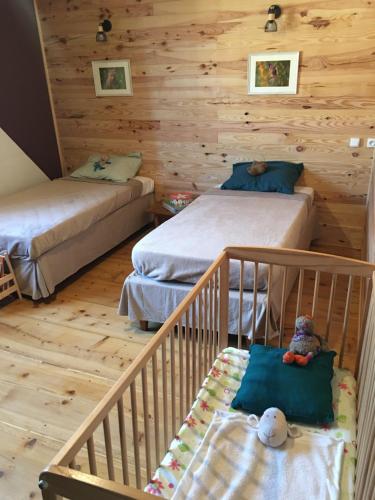 - une chambre avec 2 lits et un lit bébé dans l'établissement Les 3Crokignols, maison d’hôte familiale., à Saffloz