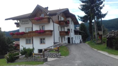 a large white house with flowers on the balconies at Pension Lucknerhof in Maranza