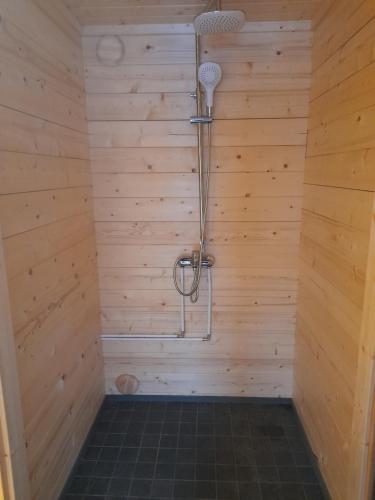 y baño con ducha en una pared de madera. en Koobamäe saunamaja en Kulli