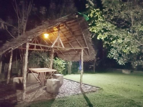 a picnic table in front of a hut at night at Green Cottage in Anuradhapura