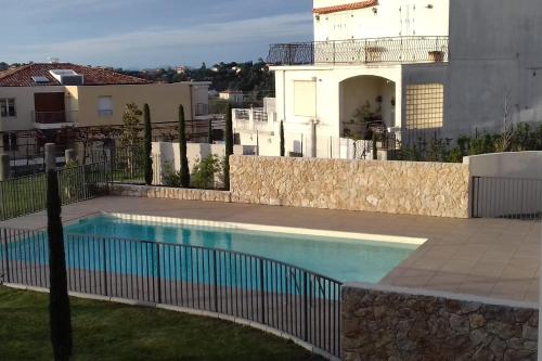 a swimming pool in front of a house at Apartment with swimming pool and garage in a standing residence in Nice