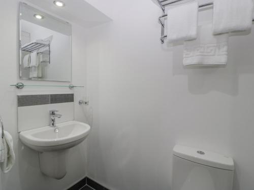 een witte badkamer met een wastafel en een toilet bij 3 The Vaults in Glastonbury