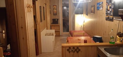 a kitchen with a counter and a refrigerator in a room at Lago Rotondo Ski House in Mezzana