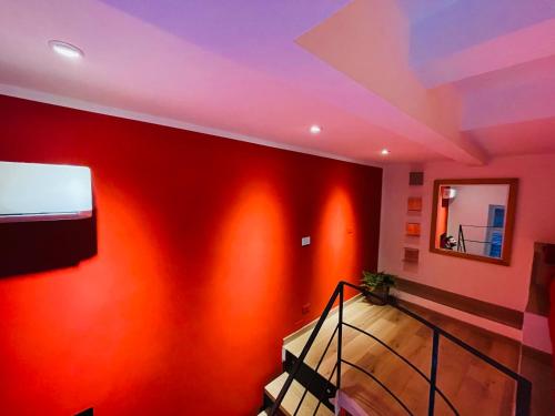 a room with a red wall and a staircase at Santa Maria La Nova 21 Rooms & Suites in Naples