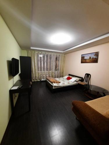a small room with a bed and a desk and a television at Шикарная 2к квартира Центральный парк Университет 70м in Irpin'