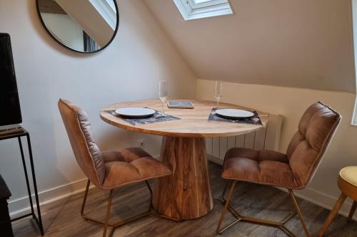 - une table ronde avec deux chaises et un miroir dans l'établissement La Mezzanine d'Au Sans Pareil- Cosy appartement city center Honfleur, à Honfleur