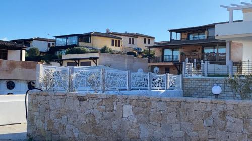 una pared de piedra frente a algunas casas en Aqualife luxury apartment, en Arzachena