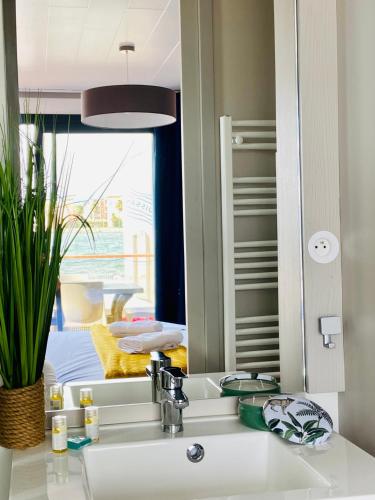 a mirror over a sink in a bathroom at Les Ilots de Gruissan in Gruissan