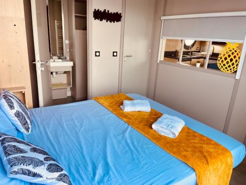 a bedroom with a blue bed with towels on it at Les Ilots de Gruissan in Gruissan