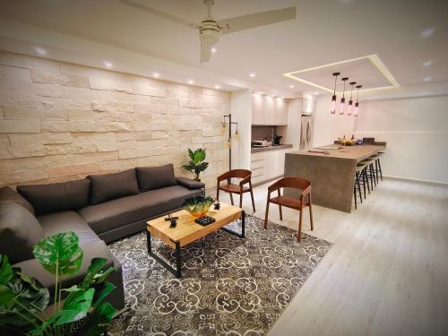 a living room with a couch and a table and a kitchen at 1st Luxury Warehouse in Cancún