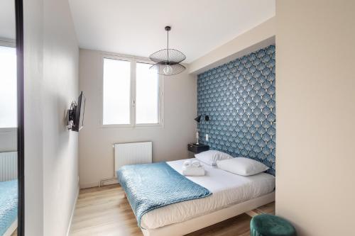 - une chambre dotée d'un lit avec un mur bleu dans l'établissement ARNEM - cosy T3, à Rennes