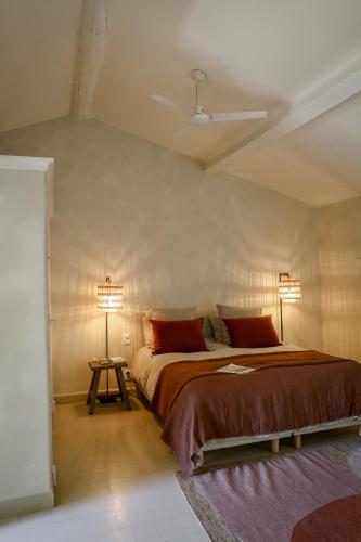 a bedroom with a bed with two lamps on it at Mas des Prêcheurs in Tarascon